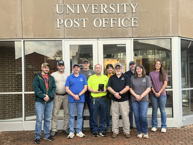 University Post Office employees pose together with their recent Mail Center of the Year Award presented by the College & University Mail Services Association