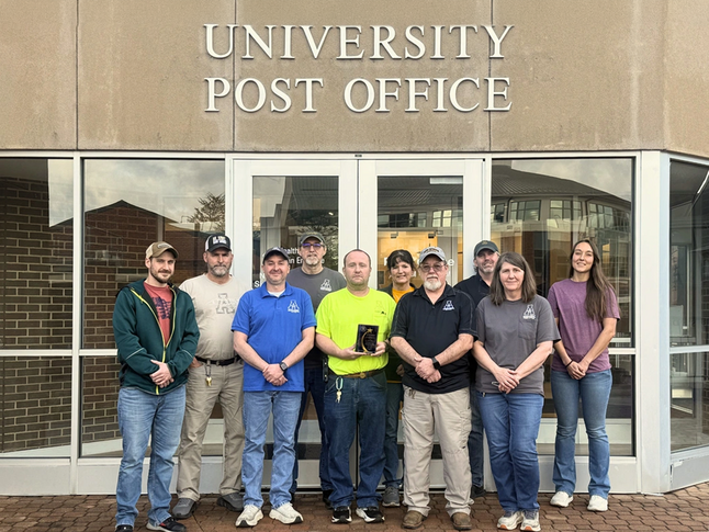 University Post Office employees pose together with their recent Mail Center of the Year Award presented by the College & University Mail Services Association.